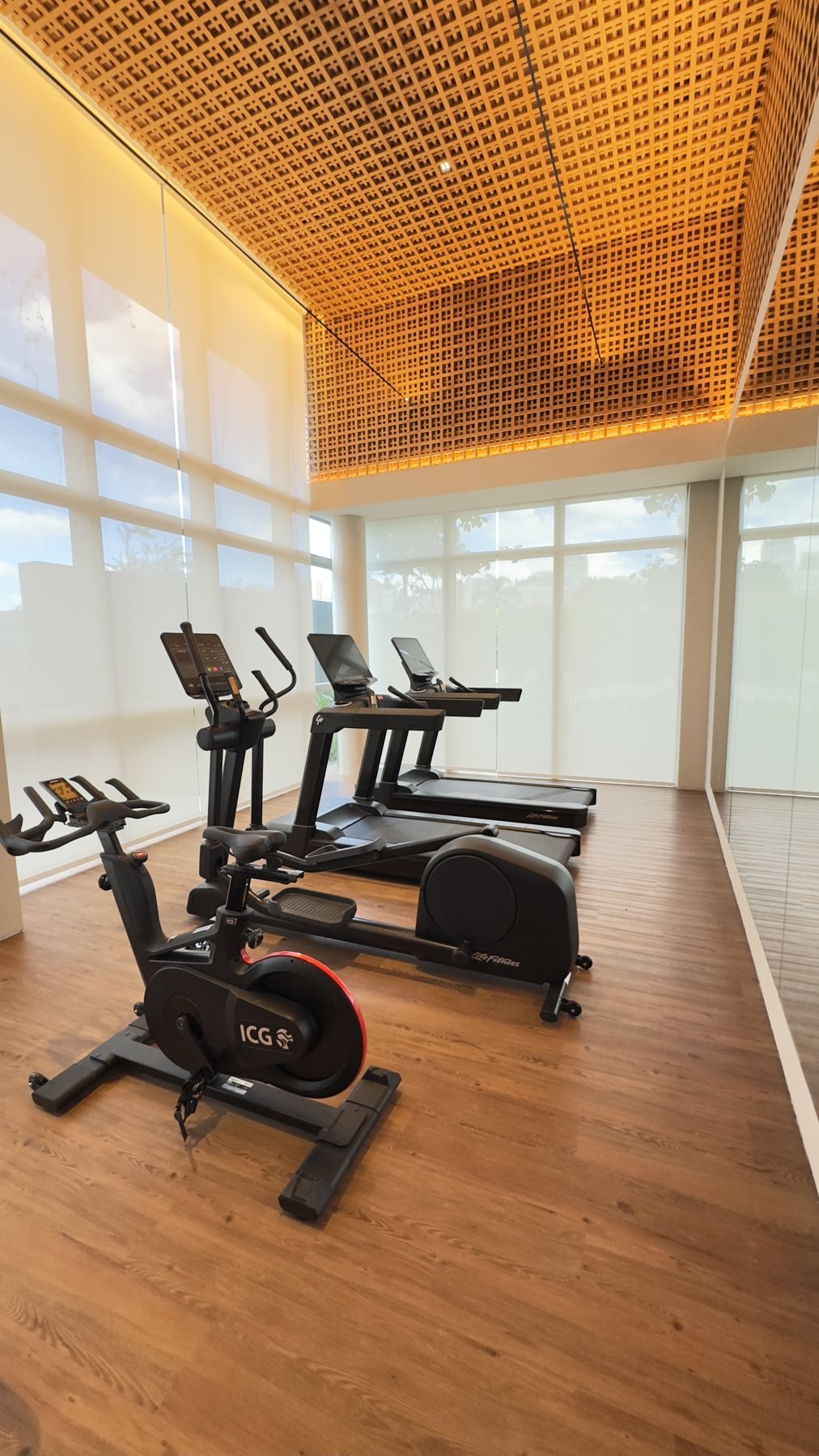Academia com equipamentos de cardio e pé-direito alto