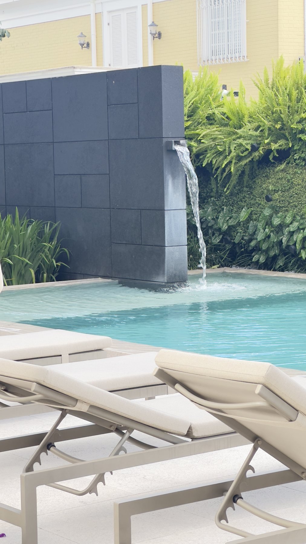 Espreguiçadeiras e cascata junto à piscina